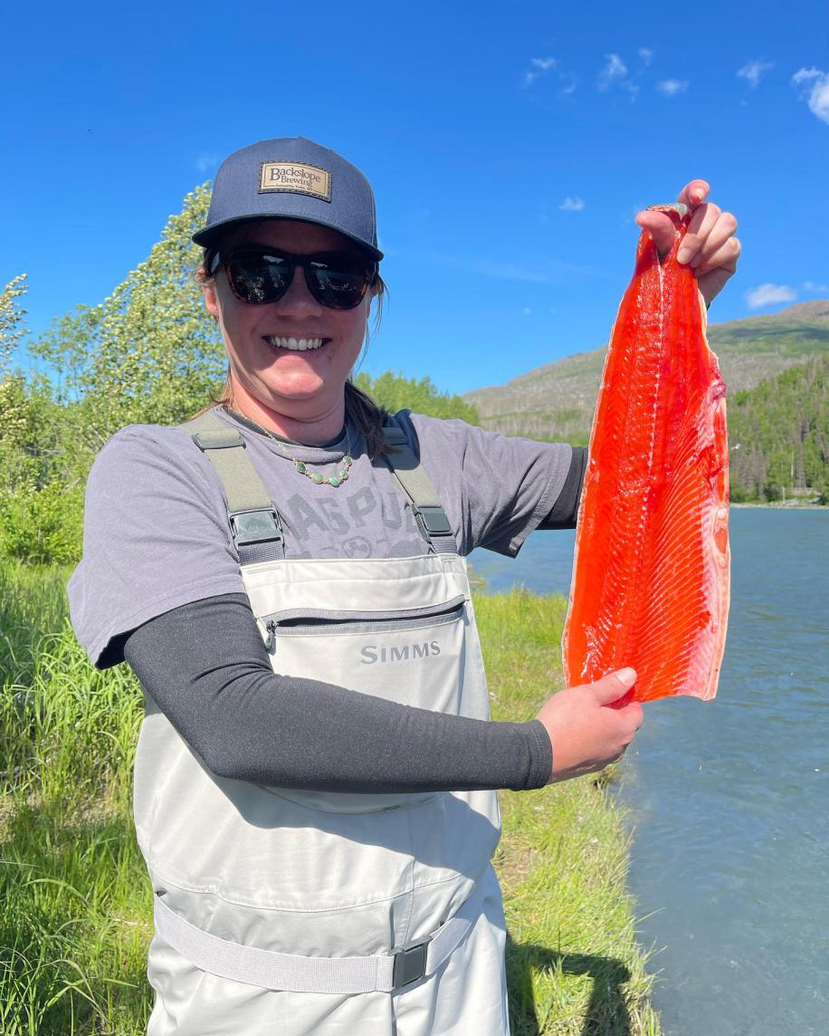 A person showing off a bright red sockeye salmon