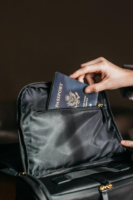 A person placing a passport on a bag, ensuring it’s easily accessible during travel.